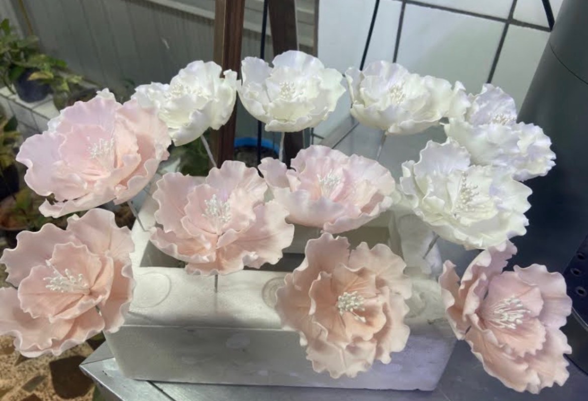Tiered wedding cake with handcrafted ivory sugar peonies